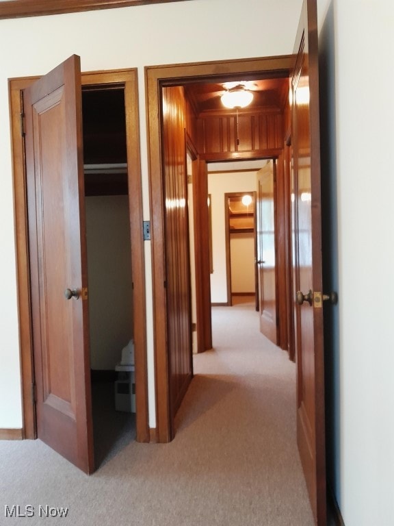 hall featuring light carpet and ornamental molding