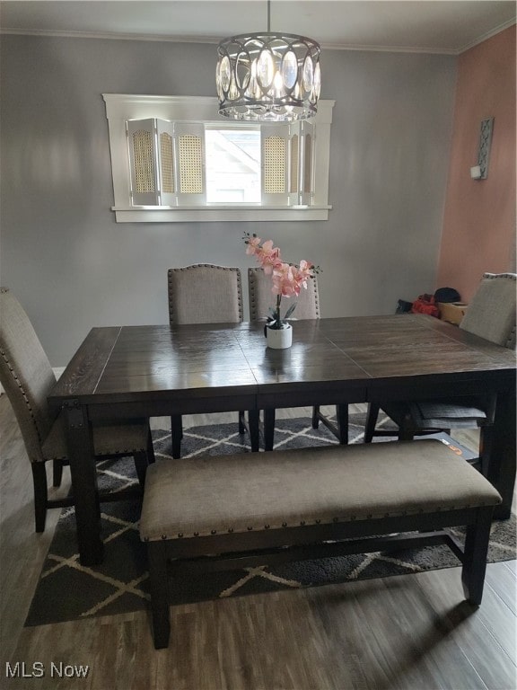 dining area with ornamental molding, hardwood / wood-style floors, and a notable chandelier