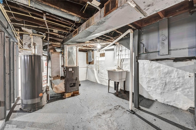 basement featuring gas water heater, electric panel, and heating unit