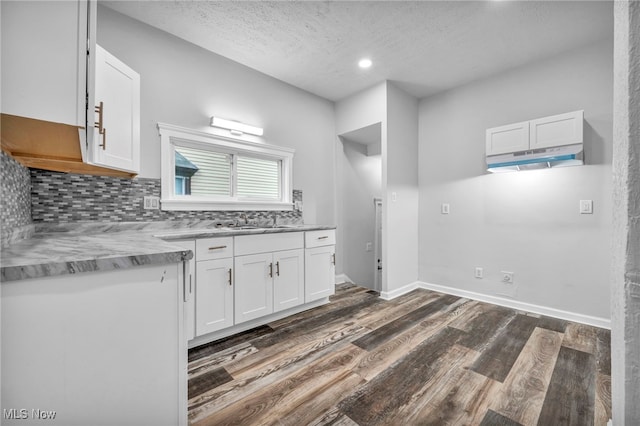 kitchen featuring white cabinetry, tasteful backsplash, a textured ceiling, dark hardwood / wood-style floors, and sink