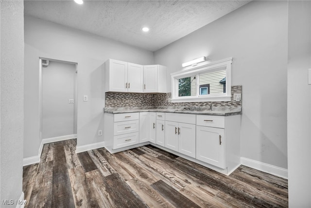 kitchen with white cabinets, a textured ceiling, tasteful backsplash, and dark hardwood / wood-style flooring