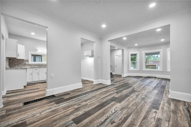 unfurnished living room featuring a textured ceiling and dark wood-type flooring