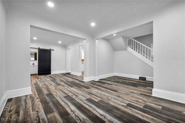 interior space with dark wood-type flooring and a barn door