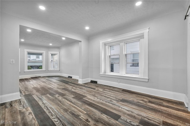 unfurnished living room featuring a textured ceiling and dark hardwood / wood-style flooring