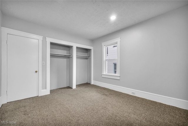 unfurnished bedroom with a textured ceiling and carpet