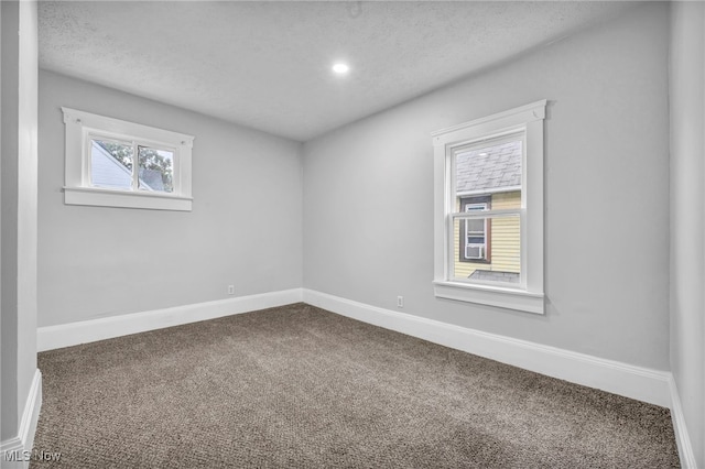 carpeted empty room with a textured ceiling