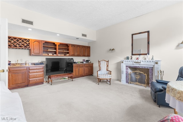 carpeted living room featuring built in desk, a textured ceiling, and a high end fireplace