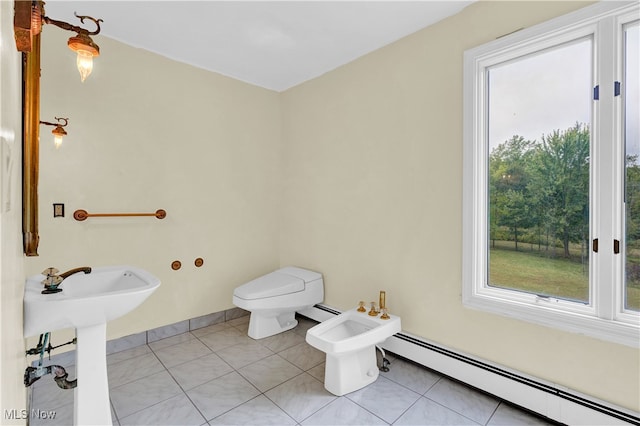 bathroom with a baseboard heating unit, a bidet, a healthy amount of sunlight, and toilet