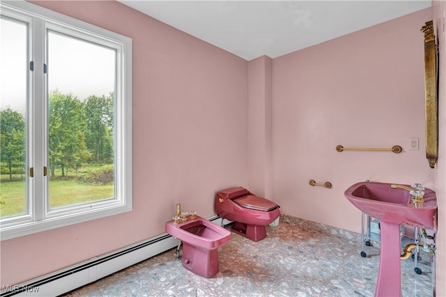 bathroom featuring toilet, a baseboard heating unit, and a bidet