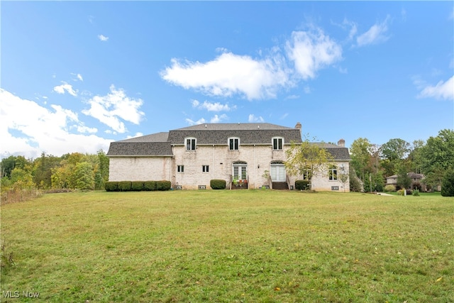 back of property featuring a lawn