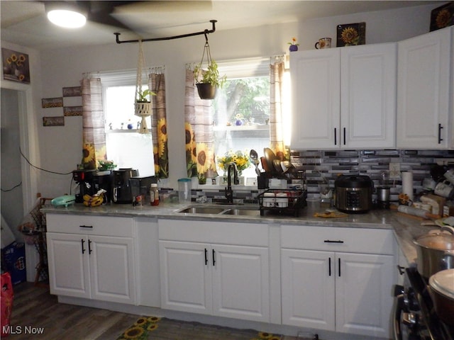 kitchen with hanging light fixtures, white cabinetry, sink, and a wealth of natural light