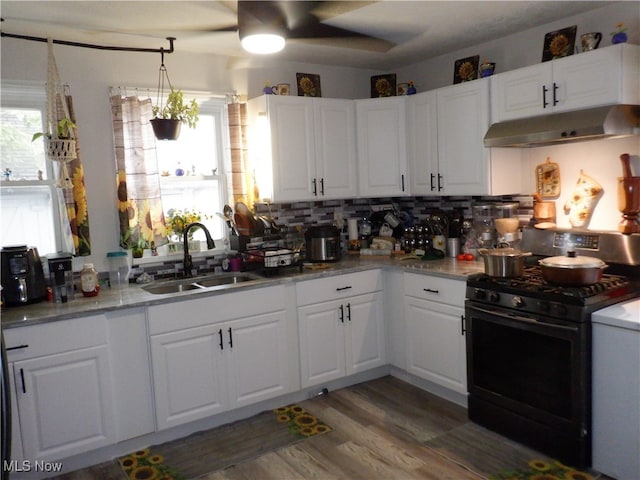 kitchen featuring black gas range oven, white cabinetry, dark wood-type flooring, and sink