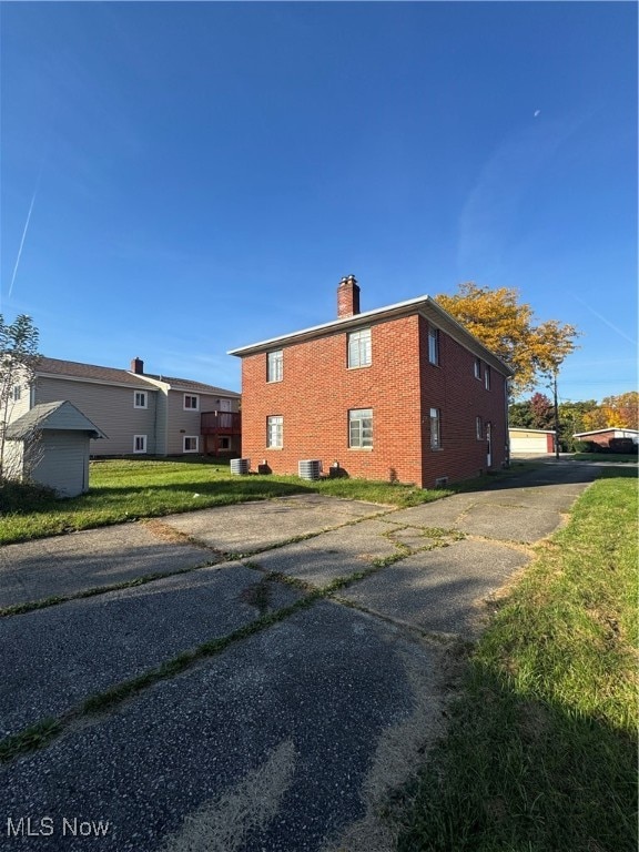 view of home's exterior with central AC and a yard