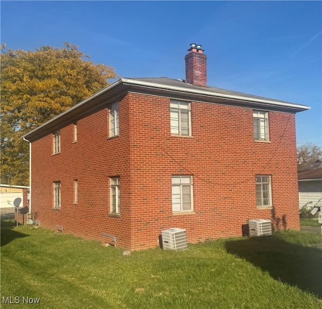 view of home's exterior featuring central AC unit and a yard