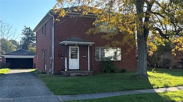 view of front of home with a garage, an outbuilding, and a front yard