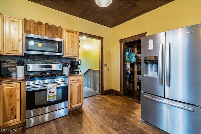 kitchen featuring stainless steel appliances, dark wood-type flooring, and tasteful backsplash