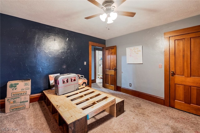 bedroom featuring ceiling fan, carpet flooring, and a textured ceiling