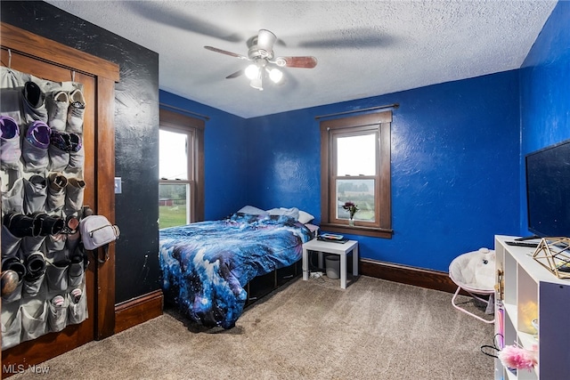 carpeted bedroom featuring a textured ceiling and ceiling fan