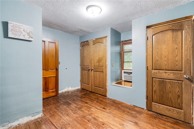 unfurnished bedroom featuring a textured ceiling and dark hardwood / wood-style floors