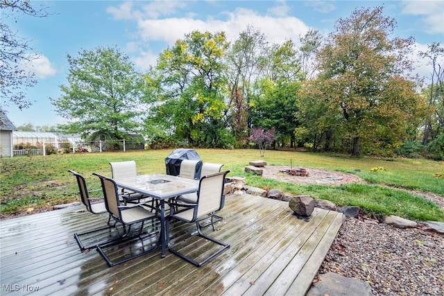 deck with an outdoor fire pit and a yard