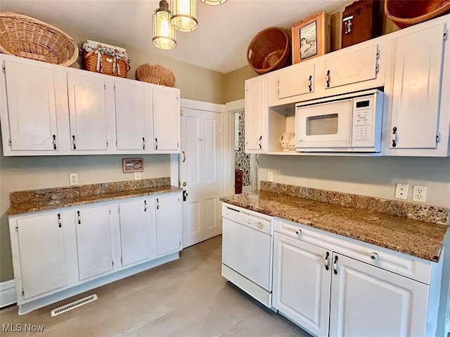 kitchen featuring dark stone countertops, white appliances, and white cabinetry