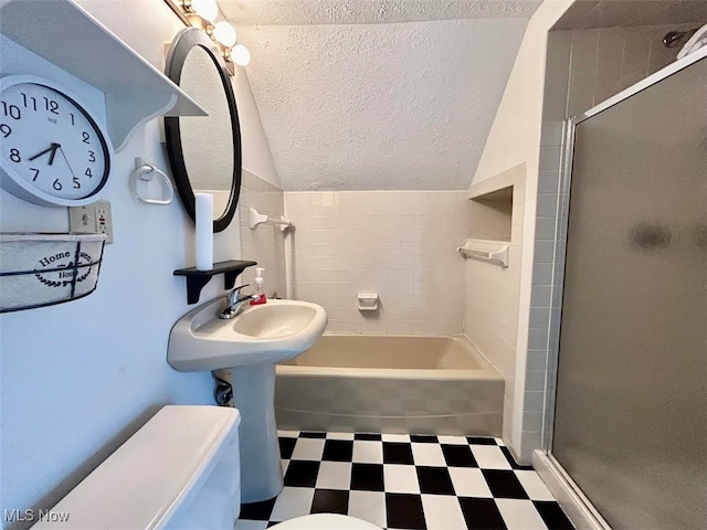 bathroom featuring a textured ceiling, lofted ceiling, and toilet