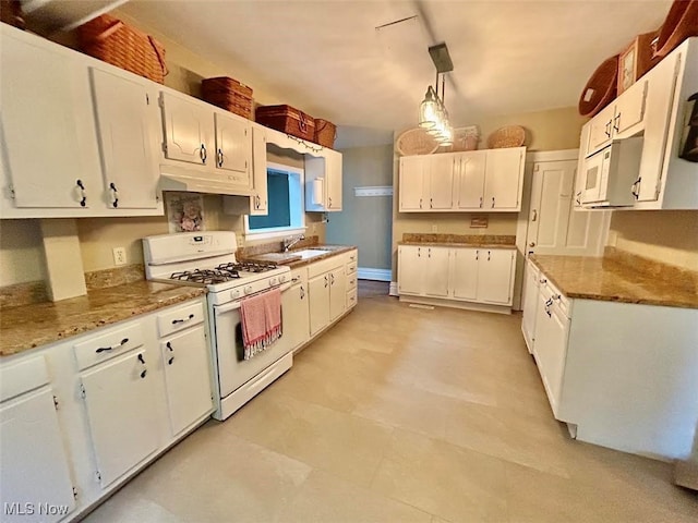 kitchen featuring hanging light fixtures, white appliances, and white cabinetry