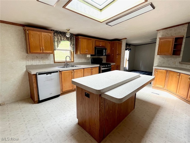 kitchen with a skylight, sink, black appliances, a center island, and a kitchen bar