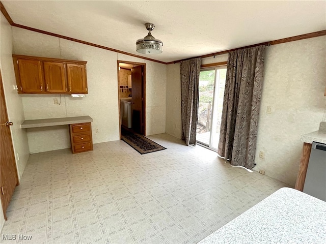 kitchen with built in desk, a textured ceiling, and crown molding