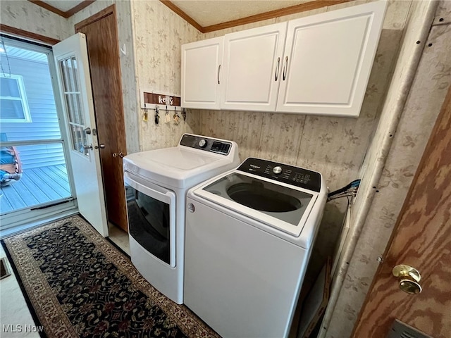 clothes washing area featuring ornamental molding, washer and dryer, and cabinets