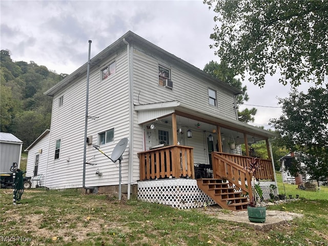 back of property featuring cooling unit, a porch, and a lawn