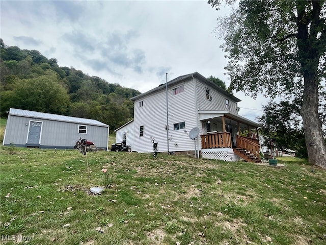 back of house featuring a storage shed and a lawn