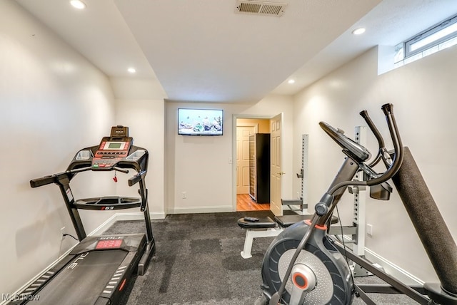 exercise room featuring dark carpet