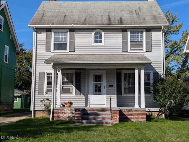 view of front of house with covered porch and a front lawn