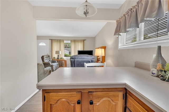 kitchen with pendant lighting, kitchen peninsula, ceiling fan, and hardwood / wood-style floors