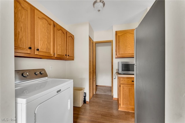 washroom with washer / clothes dryer, dark hardwood / wood-style flooring, and cabinets