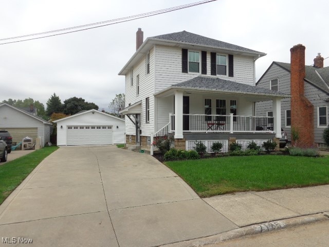 view of front facade with an outbuilding, a garage, a front yard, and covered porch