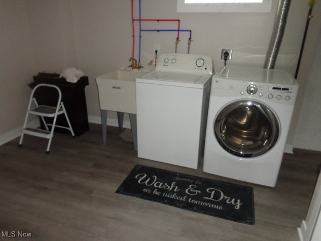 clothes washing area with hardwood / wood-style floors and independent washer and dryer