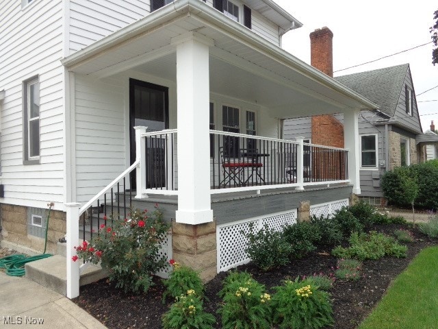 view of side of home featuring covered porch