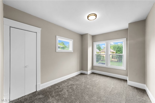 unfurnished bedroom with a closet and carpet flooring