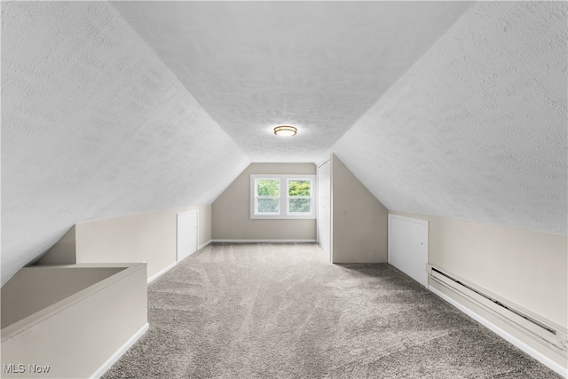 bonus room with a textured ceiling, carpet, vaulted ceiling, and a baseboard heating unit