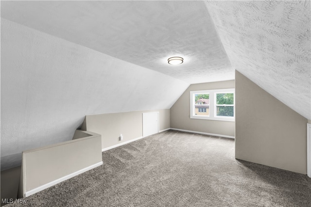 bonus room featuring a textured ceiling, lofted ceiling, and carpet