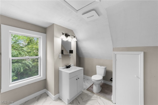 bathroom featuring vanity, lofted ceiling, and toilet