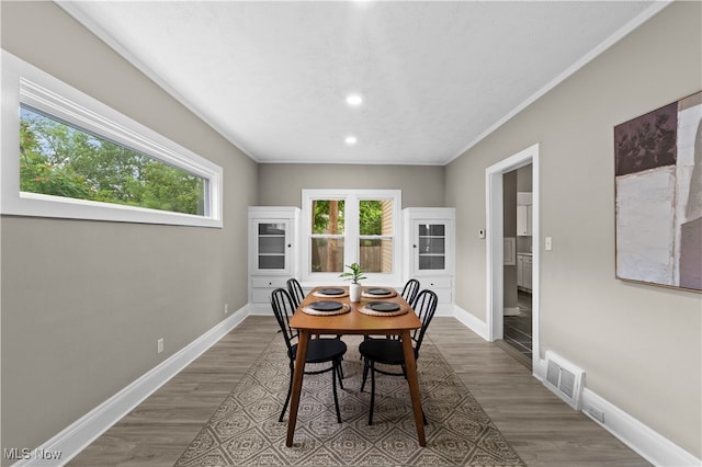 dining room featuring hardwood / wood-style flooring and crown molding