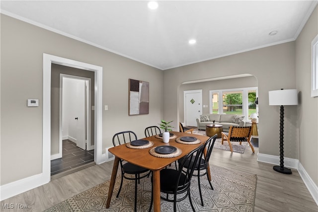 dining area with wood-type flooring and ornamental molding