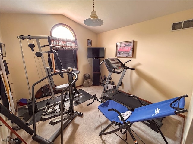 workout room with lofted ceiling and light carpet