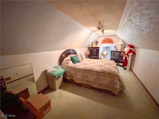 carpeted bedroom with lofted ceiling and a textured ceiling