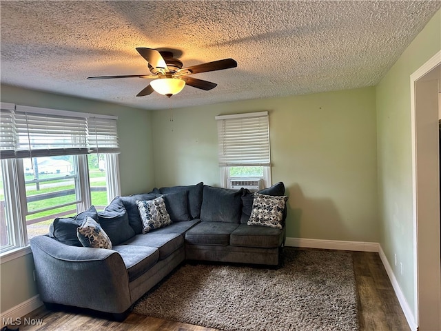 living room featuring a textured ceiling, wood-type flooring, and ceiling fan