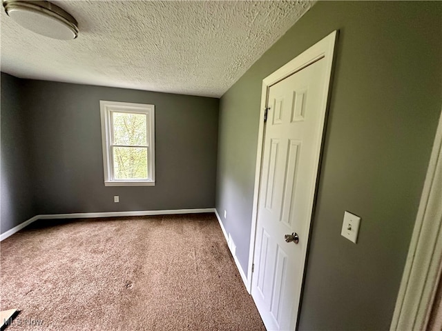 carpeted spare room with a textured ceiling