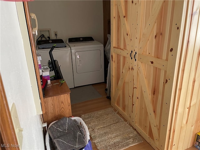 laundry area featuring washer and dryer and light hardwood / wood-style flooring